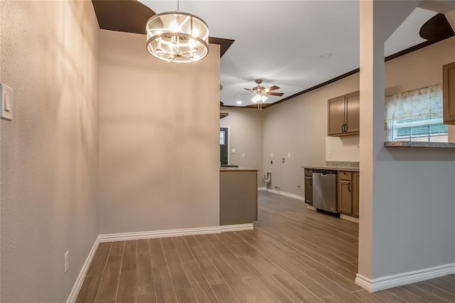 interior space with light stone counters, dishwasher, hardwood / wood-style floors, and ceiling fan with notable chandelier