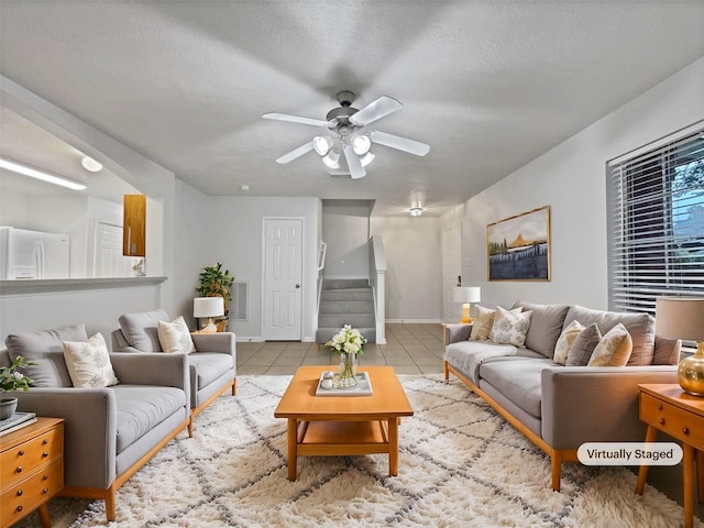 tiled living room featuring ceiling fan and a textured ceiling