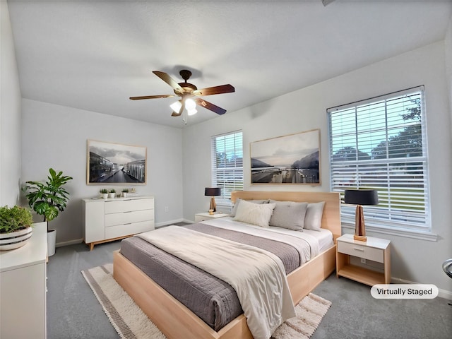 carpeted bedroom featuring multiple windows and ceiling fan