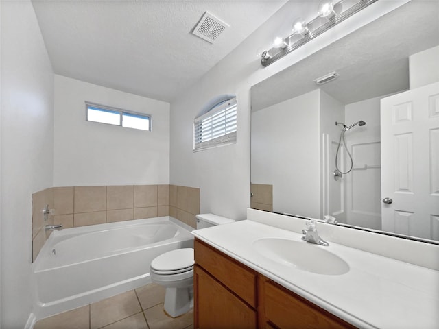 bathroom with tile patterned flooring, a tub to relax in, a textured ceiling, toilet, and vanity