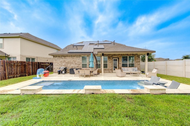 rear view of house featuring solar panels, an outdoor hangout area, a patio, and a lawn