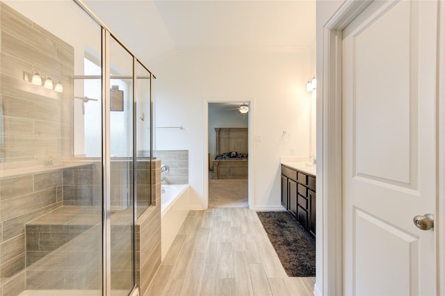 bathroom featuring hardwood / wood-style floors, plenty of natural light, lofted ceiling, and vanity