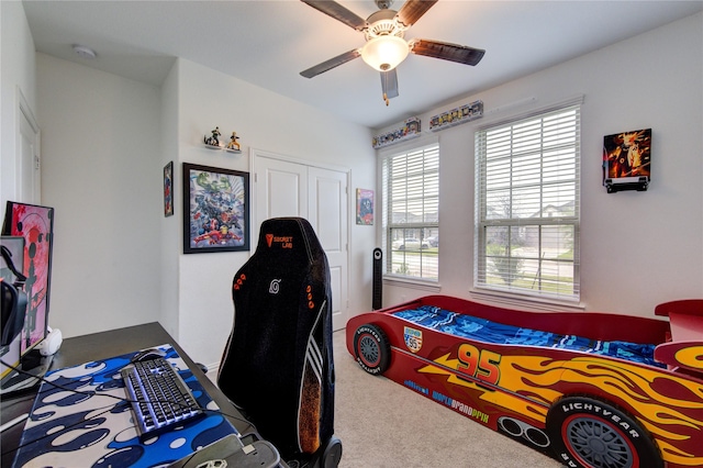 carpeted bedroom with ceiling fan and a closet