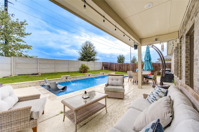 view of pool with an outdoor living space, pool water feature, and a patio