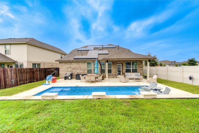 rear view of house featuring solar panels, a patio area, an outdoor hangout area, and a yard