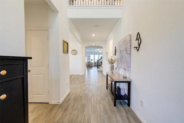 hallway with crown molding and light hardwood / wood-style flooring