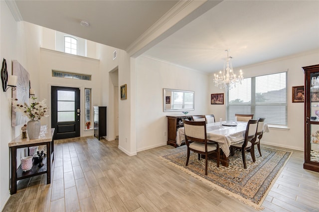 dining area with ornamental molding, light hardwood / wood-style flooring, a healthy amount of sunlight, and a notable chandelier