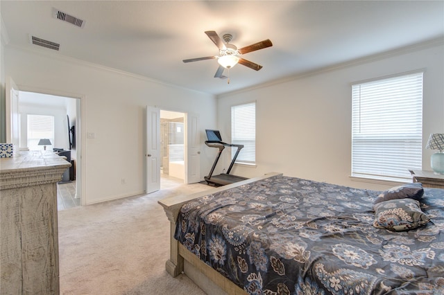 bedroom with ceiling fan, light carpet, connected bathroom, and multiple windows