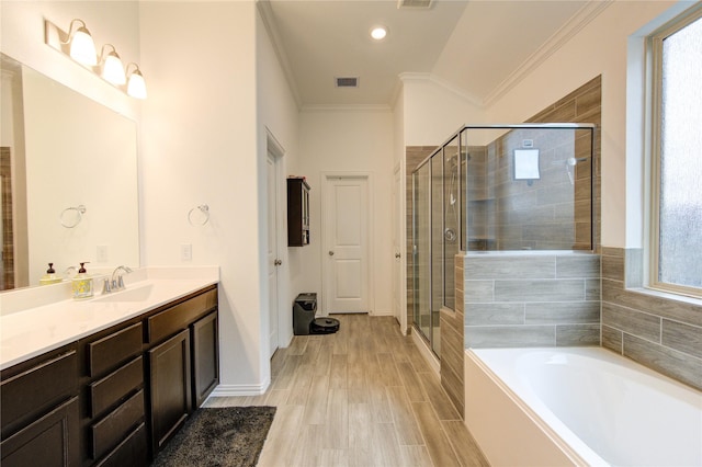 bathroom featuring a wealth of natural light, crown molding, wood-type flooring, and shower with separate bathtub