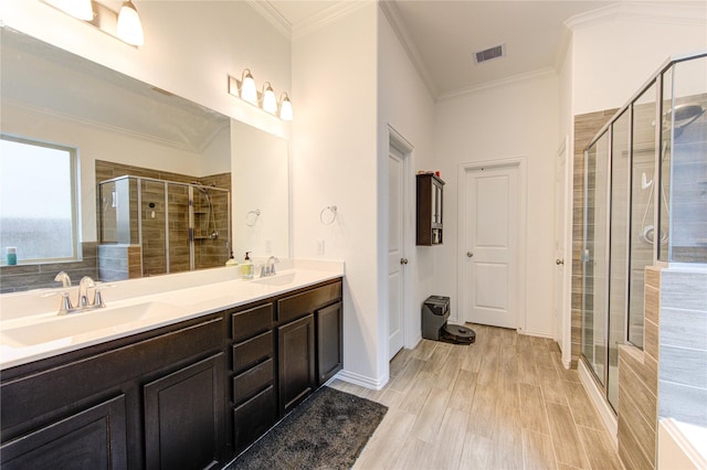 bathroom featuring a shower with shower door, wood-type flooring, crown molding, and vanity