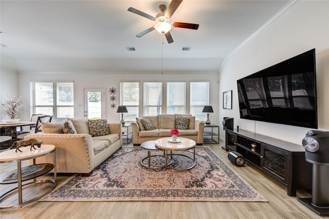 living room with ceiling fan, light hardwood / wood-style flooring, crown molding, and lofted ceiling