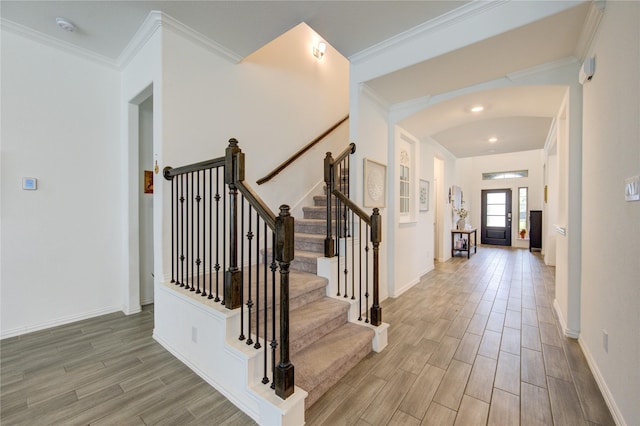 foyer entrance featuring light hardwood / wood-style floors and crown molding