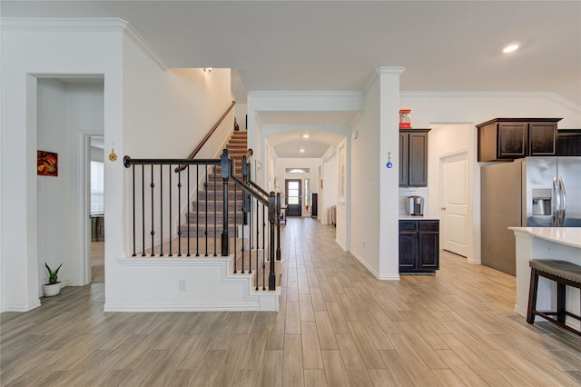 entrance foyer with ornamental molding and light hardwood / wood-style flooring