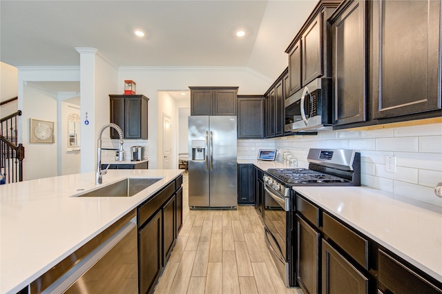 kitchen with dark brown cabinets, sink, lofted ceiling, and appliances with stainless steel finishes