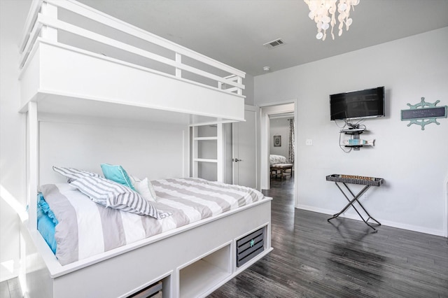 bedroom featuring dark hardwood / wood-style flooring and a chandelier