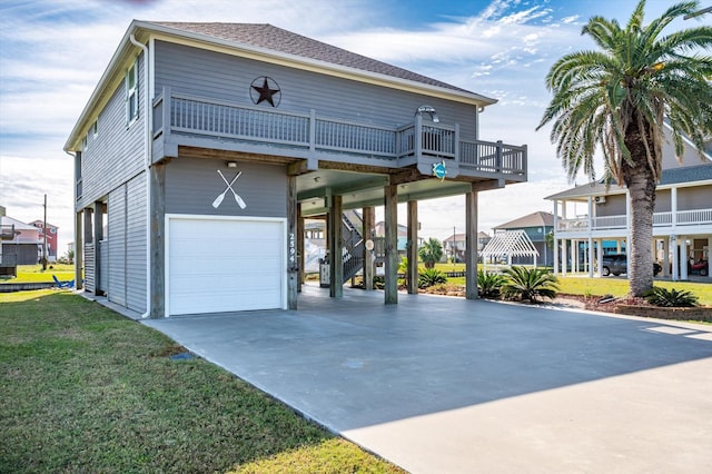 view of front of house with a balcony, a front lawn, a carport, and a garage