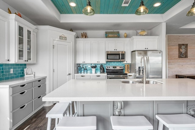 kitchen with a kitchen bar, hanging light fixtures, and appliances with stainless steel finishes