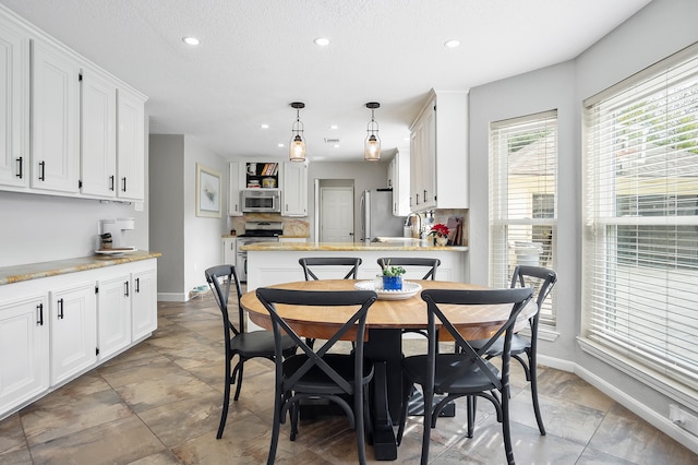 dining room with a textured ceiling and sink