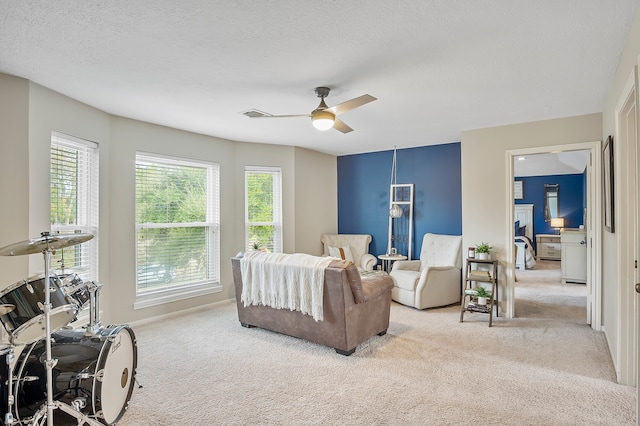 carpeted bedroom featuring a textured ceiling and ceiling fan