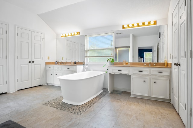 bathroom with vanity, independent shower and bath, and vaulted ceiling