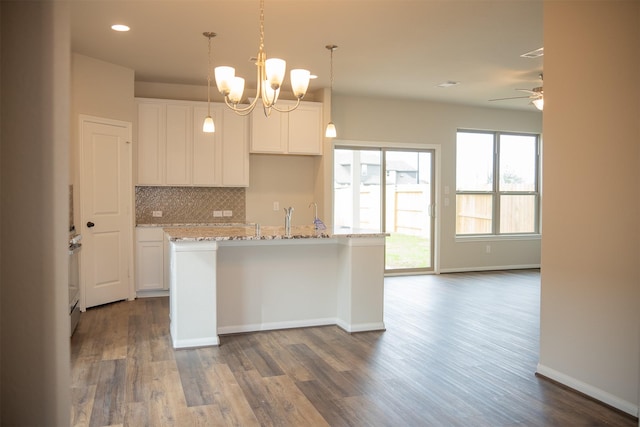 kitchen featuring a center island with sink, dark hardwood / wood-style floors, white cabinetry, and ceiling fan with notable chandelier