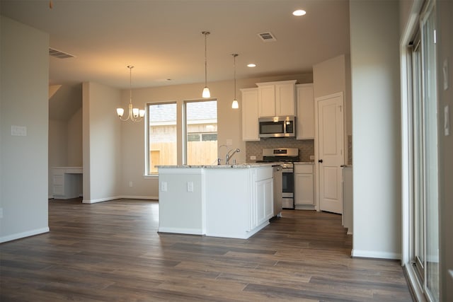 kitchen with an island with sink, dark hardwood / wood-style flooring, light stone counters, white cabinetry, and stainless steel appliances