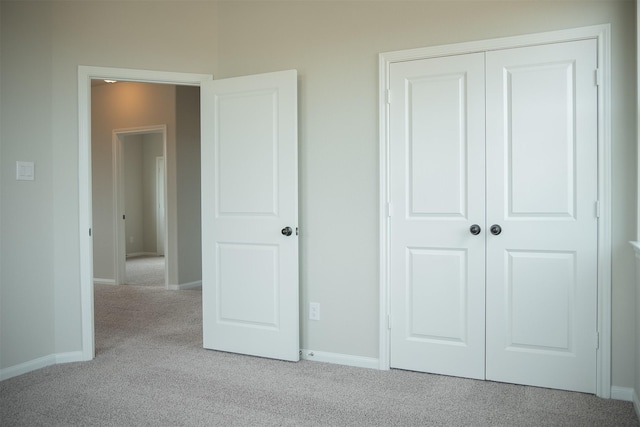 unfurnished bedroom with light carpet and a closet