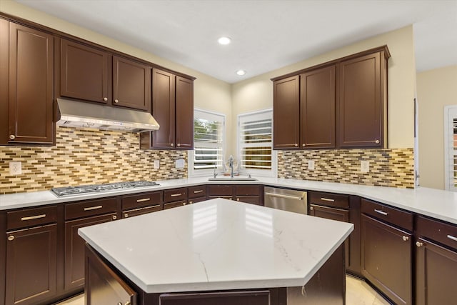 7411 Shady Arbour Ct, Pasadena, TX 77505 - kitchen with under cabinet range hood, stainless steel appliances, a kitchen island, recessed lighting, and decorative backsplash