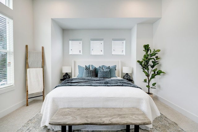 carpeted bedroom featuring multiple windows