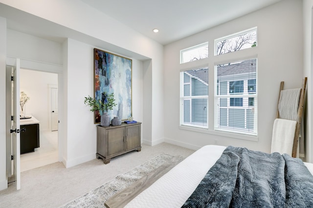 bedroom featuring light colored carpet and connected bathroom