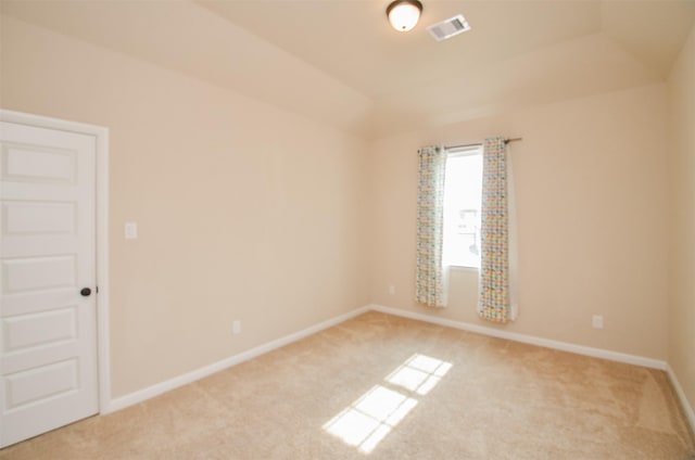 carpeted empty room featuring lofted ceiling