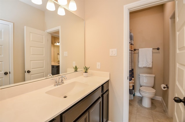 bathroom with toilet, vanity, and tile patterned floors