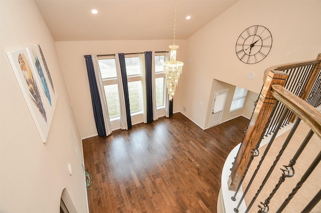 entryway featuring dark hardwood / wood-style flooring, high vaulted ceiling, and a notable chandelier