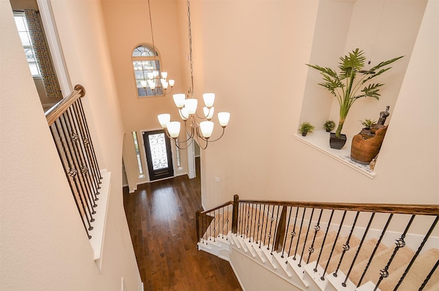 foyer entrance with dark hardwood / wood-style floors, a high ceiling, and an inviting chandelier