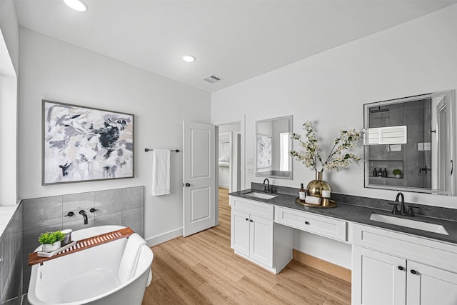 bathroom with separate shower and tub, hardwood / wood-style flooring, and vanity