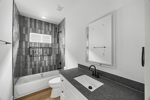 full bathroom with wood-type flooring, toilet, vanity, and tiled shower / bath