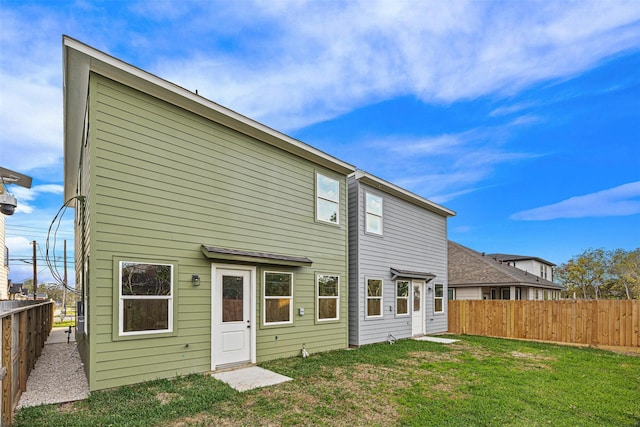 rear view of property featuring a lawn