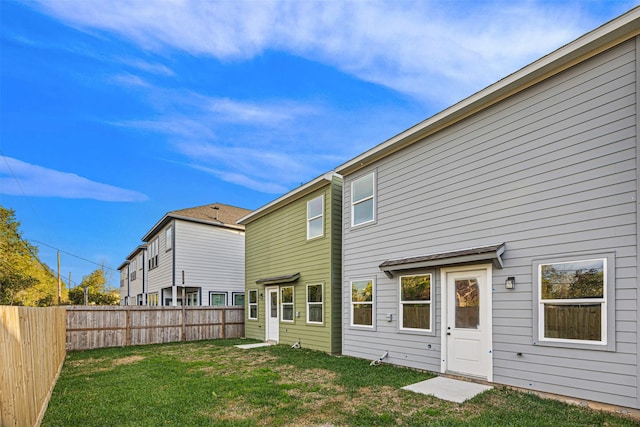 rear view of property with a yard