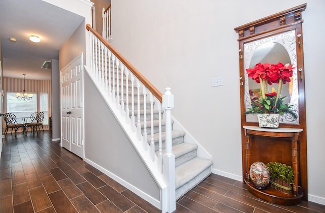 stairs featuring a notable chandelier