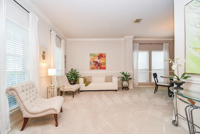 sitting room featuring light carpet, a wealth of natural light, and crown molding