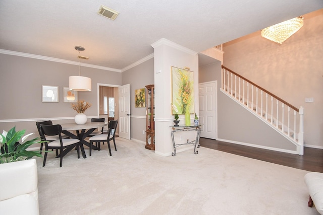 dining area featuring crown molding, a chandelier, and carpet flooring