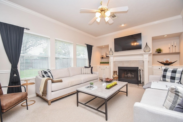 carpeted living room with ceiling fan, a fireplace, and ornamental molding