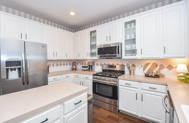 kitchen featuring appliances with stainless steel finishes, backsplash, and white cabinetry