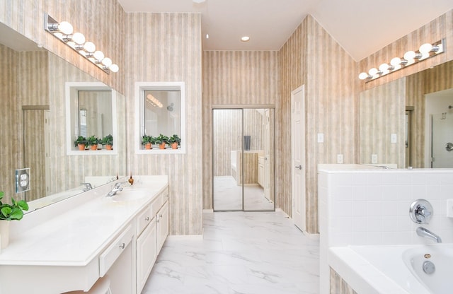 bathroom featuring vanity and a relaxing tiled tub