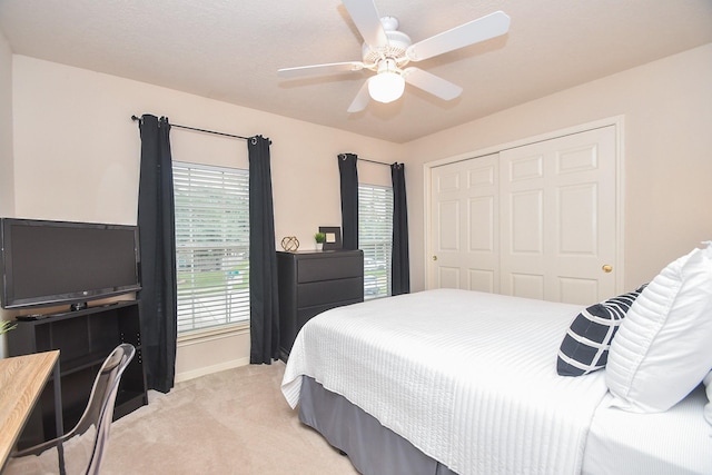 carpeted bedroom featuring ceiling fan, a closet, and multiple windows