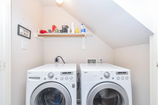 clothes washing area with washer and dryer and a textured ceiling