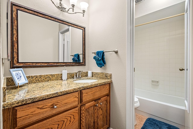 full bathroom with vanity, tiled shower / bath combo, and toilet