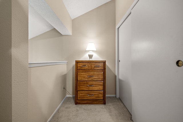 interior space featuring light colored carpet and vaulted ceiling