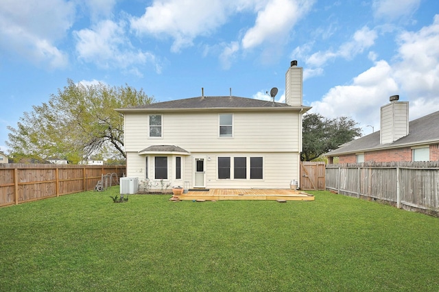 back of house featuring a lawn, a wooden deck, and central AC