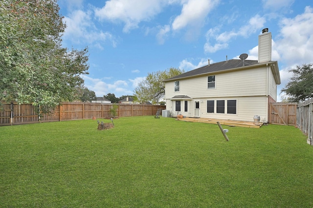 back of property with a yard, a wooden deck, and central air condition unit